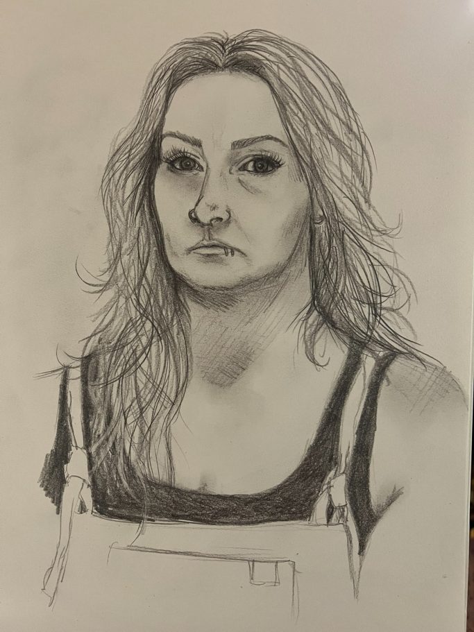 Portrait of a woman with long hair, wearing a dark top and looking serious.