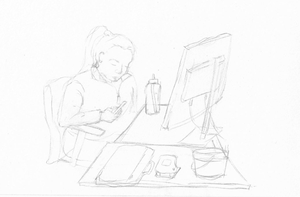 A person sitting at a desk, focused on a phone with a computer in front.