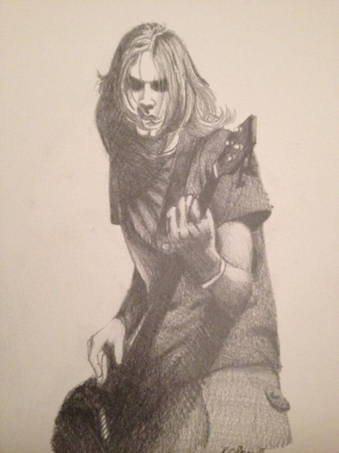 A person with long hair passionately playing an electric guitar.