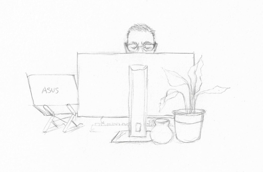 Person sitting at a desk with two computers, a plant, and a fruit.